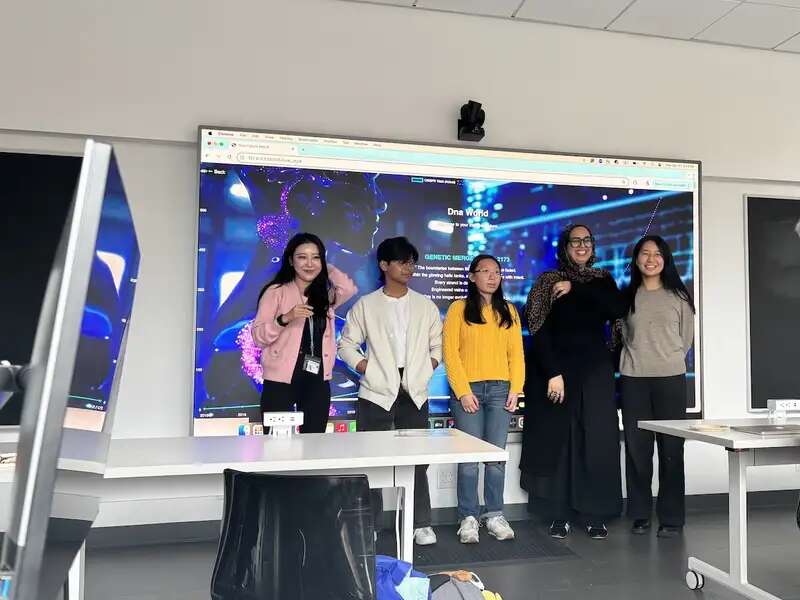 Five students stand in front of the viz wall, which showcases a project with a brightly-colored background